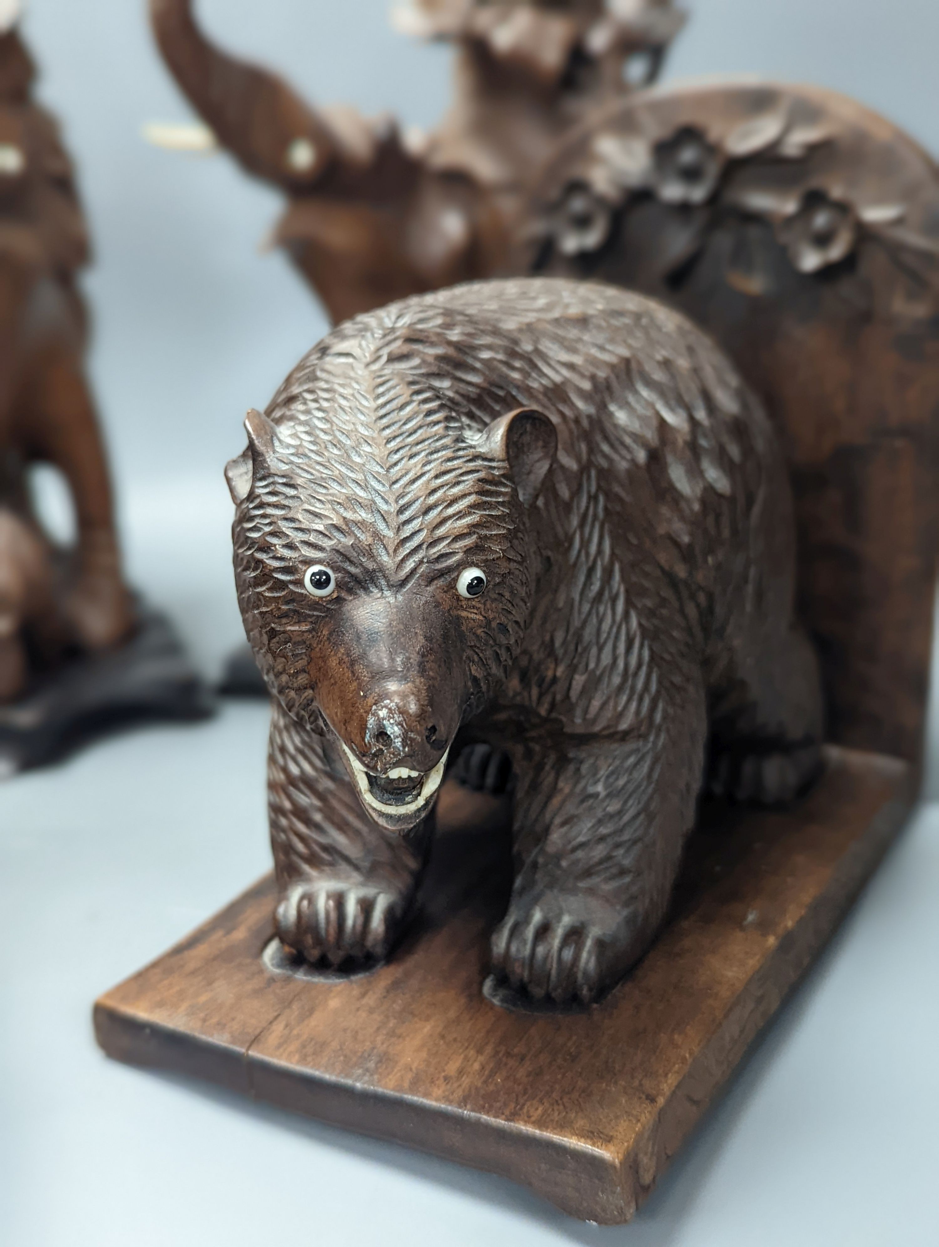 A pair of Chinese wood carvings figures on elephants, a pair of Chinese bear bookends, Chines figures 26 cms high.